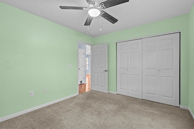 unfurnished bedroom with ceiling fan, light carpet, and a closet