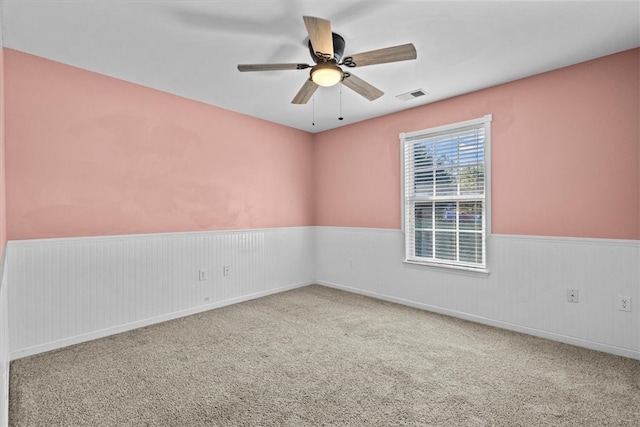 carpeted spare room featuring ceiling fan