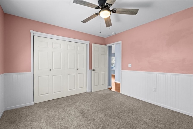 unfurnished bedroom featuring carpet flooring, a closet, and ceiling fan