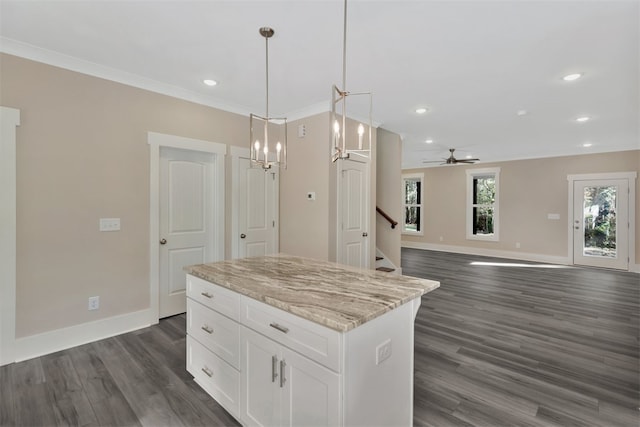 kitchen with pendant lighting, dark wood-type flooring, ceiling fan, a kitchen island, and white cabinetry