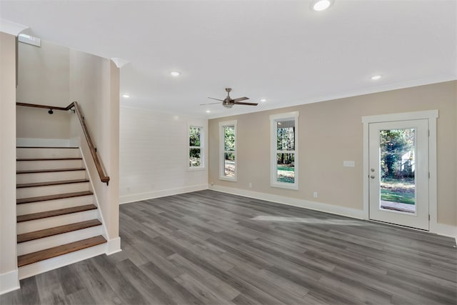 unfurnished living room with plenty of natural light, ceiling fan, dark hardwood / wood-style flooring, and crown molding