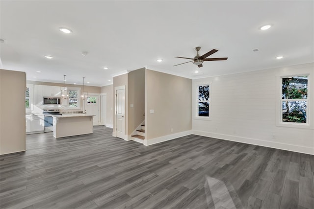 unfurnished living room featuring dark hardwood / wood-style floors, ceiling fan, and ornamental molding