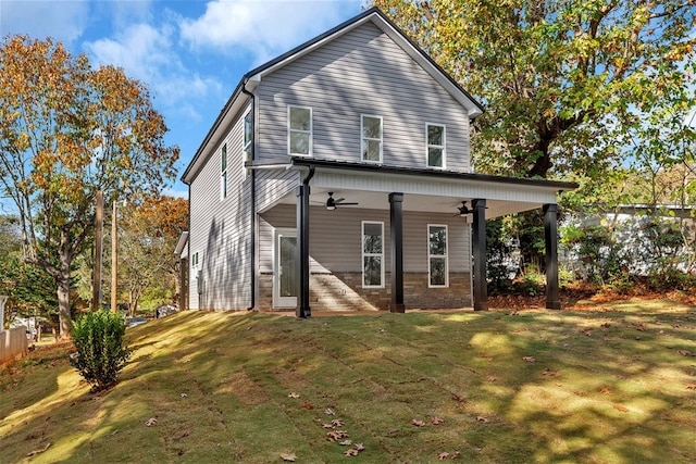 back of house featuring ceiling fan and a yard