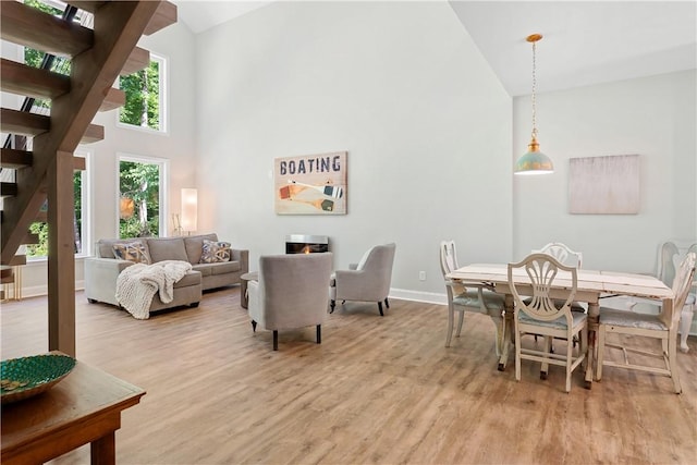 dining area featuring plenty of natural light, a high ceiling, and light wood-type flooring