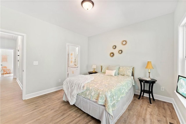 bedroom featuring ensuite bathroom and light hardwood / wood-style flooring