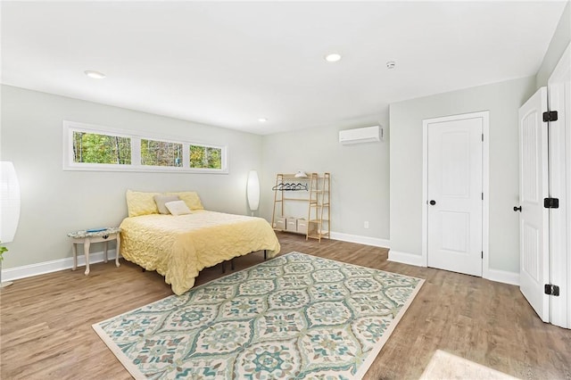 bedroom featuring wood-type flooring and a wall mounted air conditioner