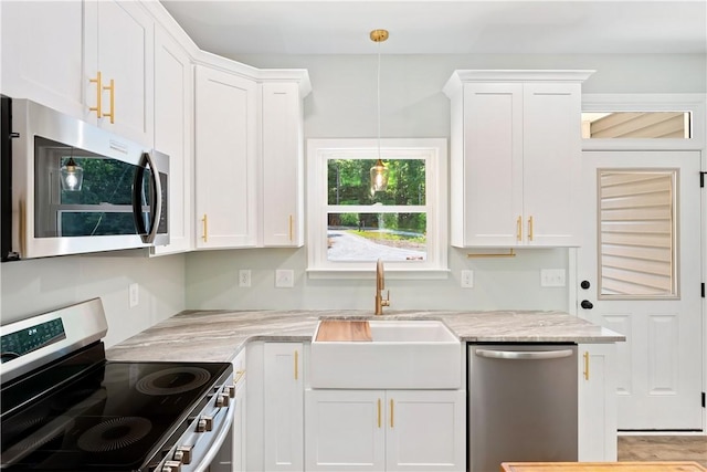 kitchen featuring pendant lighting, white cabinets, and appliances with stainless steel finishes