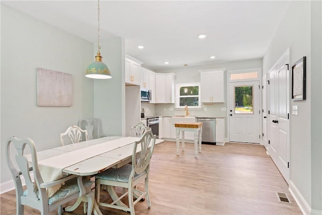 dining room with light hardwood / wood-style floors and sink