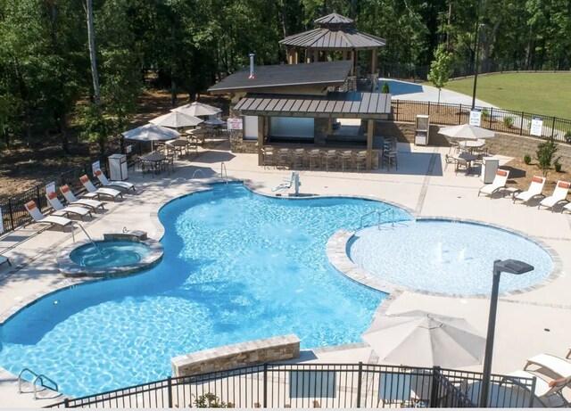 view of pool with a gazebo, an outdoor bar, a hot tub, and a patio