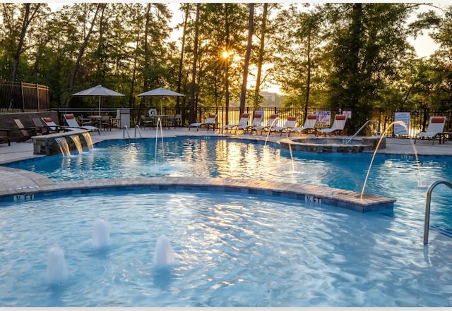 view of pool featuring pool water feature, a community hot tub, and a patio