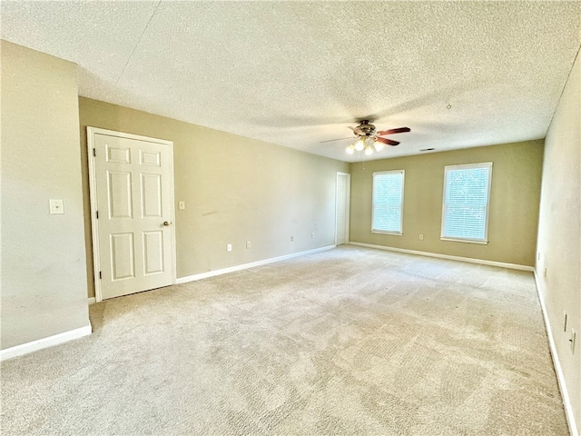 carpeted empty room featuring ceiling fan and a textured ceiling