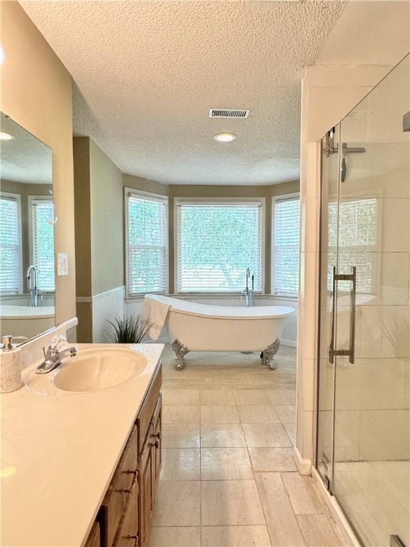 bathroom featuring vanity, a textured ceiling, and shower with separate bathtub