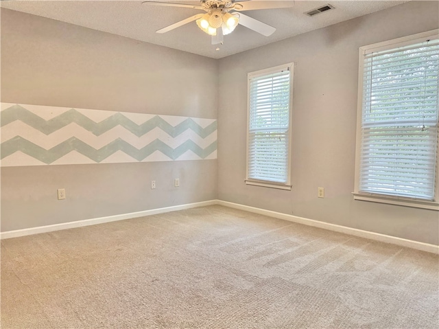 empty room featuring ceiling fan, carpet floors, and a textured ceiling