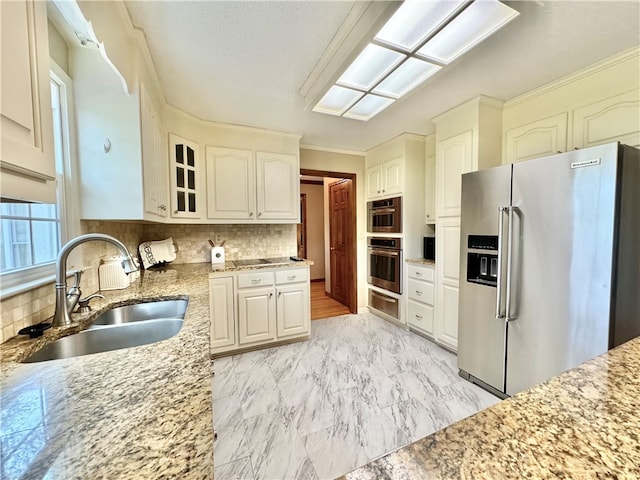 kitchen featuring white cabinets, decorative backsplash, sink, and appliances with stainless steel finishes