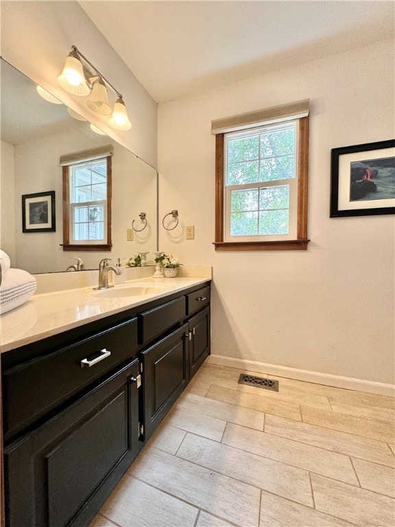 bathroom with vanity, a healthy amount of sunlight, and wood-type flooring