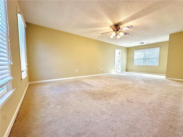 unfurnished room with a textured ceiling, carpet floors, and ceiling fan