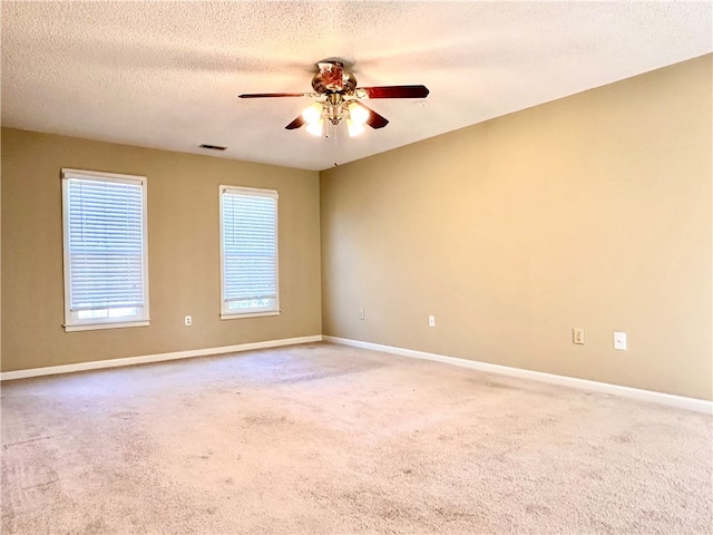 empty room featuring carpet, a textured ceiling, and ceiling fan