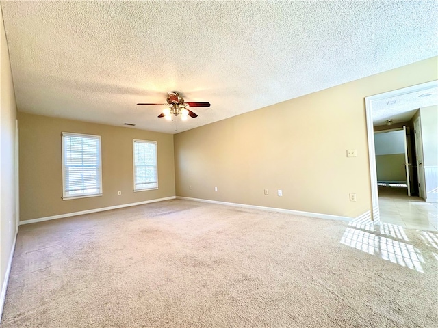 carpeted spare room featuring ceiling fan and a textured ceiling