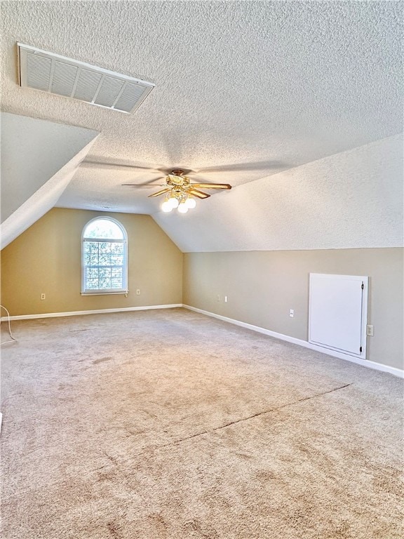 bonus room with vaulted ceiling, ceiling fan, carpet flooring, and a textured ceiling