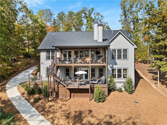 rear view of property featuring a wooden deck