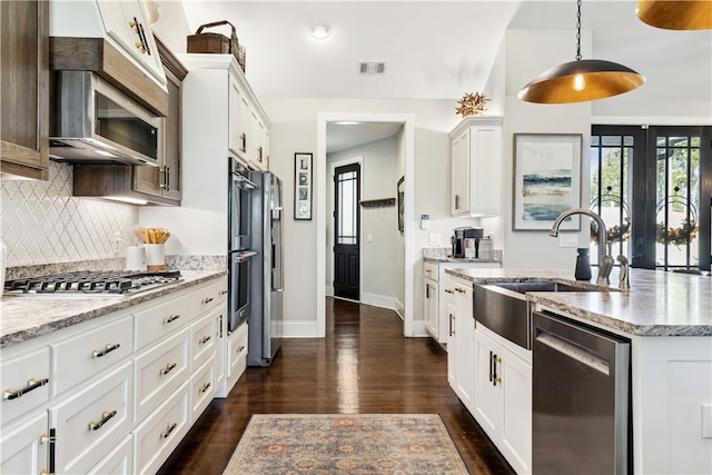 kitchen with white cabinetry, sink, dark wood-type flooring, stainless steel appliances, and pendant lighting