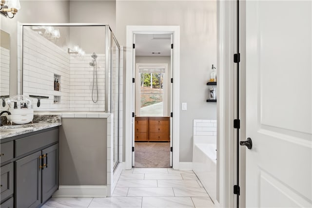 bathroom with vanity and shower with separate bathtub