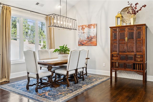 dining area with hardwood / wood-style flooring and an inviting chandelier