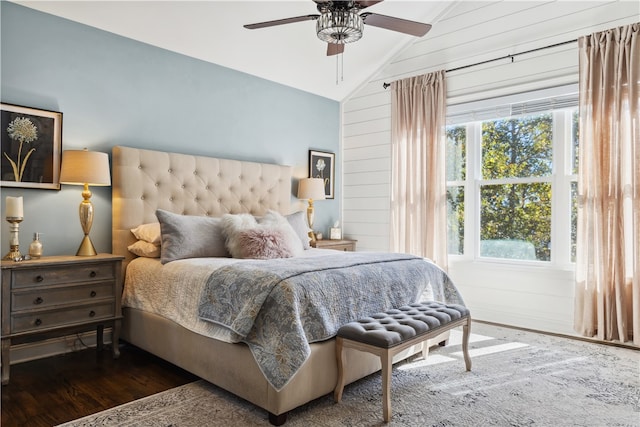 bedroom with wood walls, dark hardwood / wood-style floors, ceiling fan, and lofted ceiling