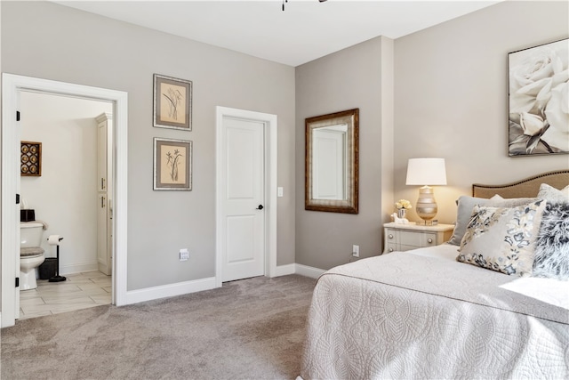 bedroom featuring light carpet and connected bathroom