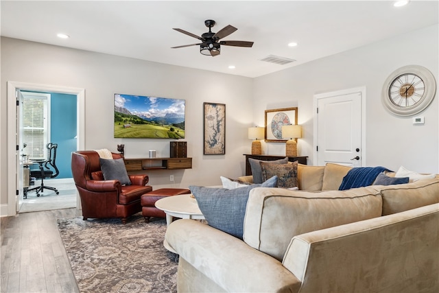 living room with wood-type flooring and ceiling fan