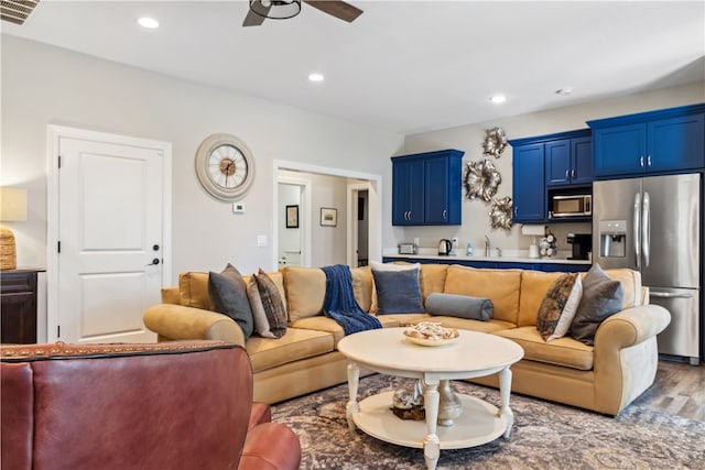 living room with ceiling fan, sink, and hardwood / wood-style flooring