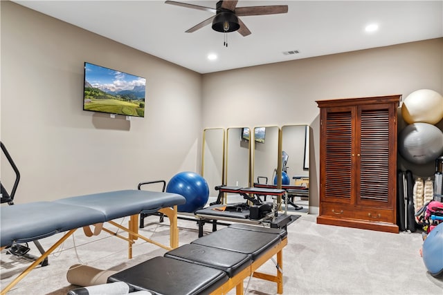 exercise room with ceiling fan and light colored carpet