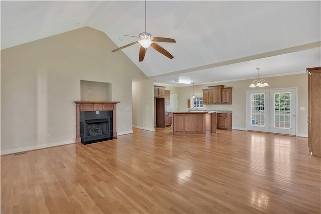 unfurnished living room featuring ceiling fan with notable chandelier, high vaulted ceiling, light hardwood / wood-style flooring, and a tiled fireplace