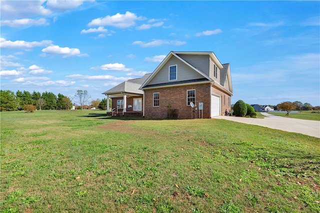 view of side of property with a yard, a porch, and a garage