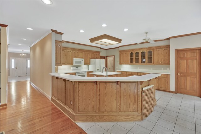 kitchen featuring ornamental molding, ceiling fan with notable chandelier, white appliances, sink, and light hardwood / wood-style flooring