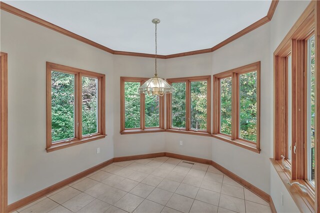 unfurnished dining area with light tile patterned floors, an inviting chandelier, and ornamental molding