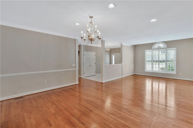 interior space with ornamental molding, light wood-type flooring, and a notable chandelier