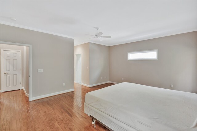 bedroom with light wood-type flooring, ceiling fan, and crown molding