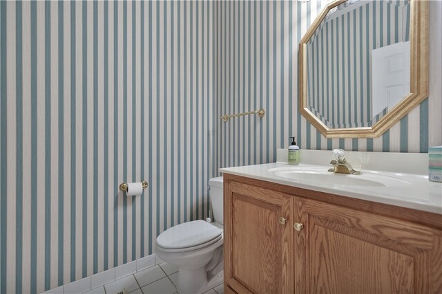 bathroom with tile patterned flooring, vanity, and toilet