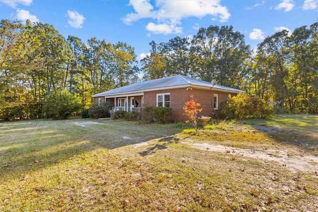 view of side of property featuring a lawn and a porch