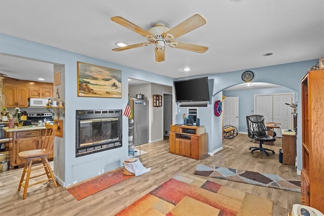 living room with light hardwood / wood-style flooring and ceiling fan