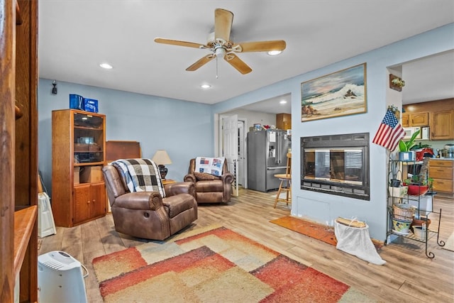 living room featuring ceiling fan and light hardwood / wood-style floors