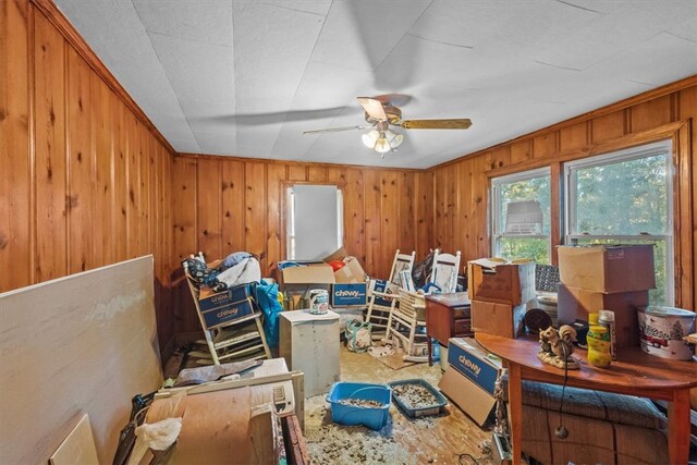 miscellaneous room with wooden walls and ceiling fan