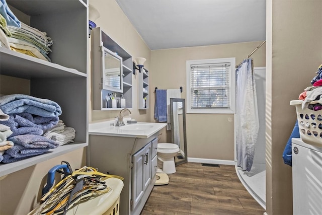 bathroom featuring vanity, toilet, wood-type flooring, and walk in shower