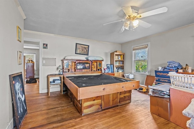 rec room featuring ceiling fan, wood-type flooring, and ornamental molding