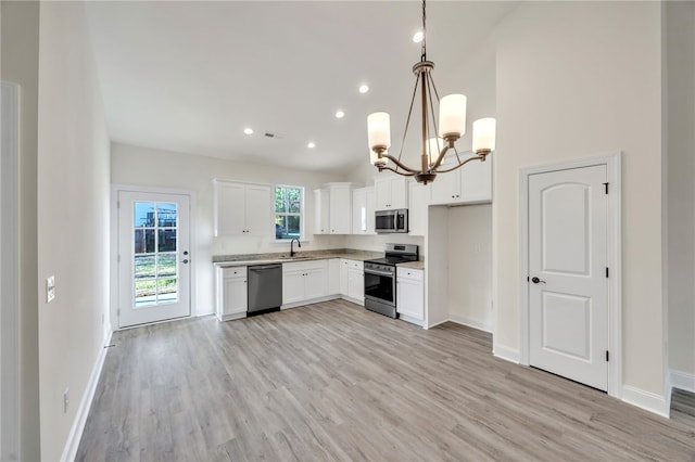 kitchen featuring sink, hanging light fixtures, stainless steel appliances, light hardwood / wood-style floors, and white cabinets