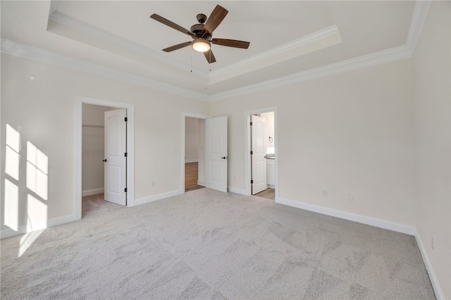 empty room with light carpet, a raised ceiling, and ornamental molding