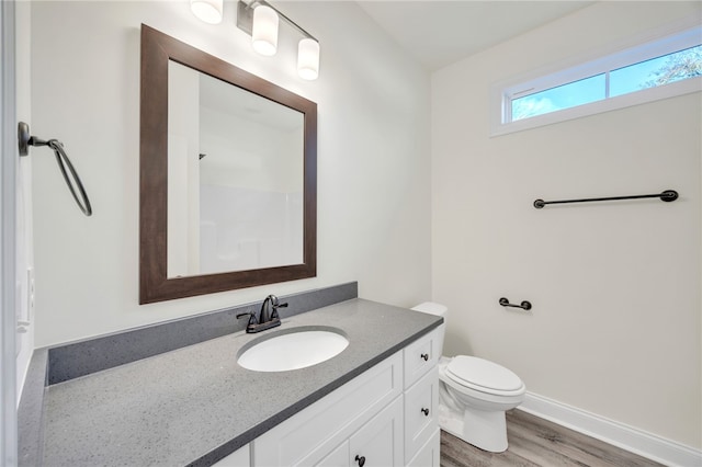 bathroom with hardwood / wood-style floors, vanity, and toilet