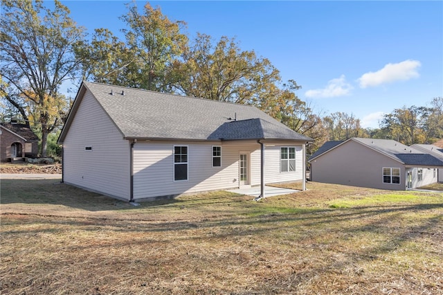 rear view of house with a patio and a lawn