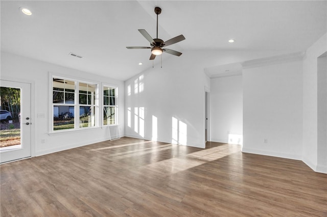 unfurnished living room featuring hardwood / wood-style floors, lofted ceiling, ceiling fan, and a healthy amount of sunlight